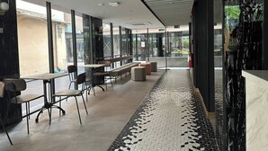 Un interior moderno con una amplia zona de asientos tipo banco, ventanas grandes y un suelo con diseño.