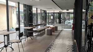 Un interior moderno con un largo pasillo, zona de estar y ventanas amplias.