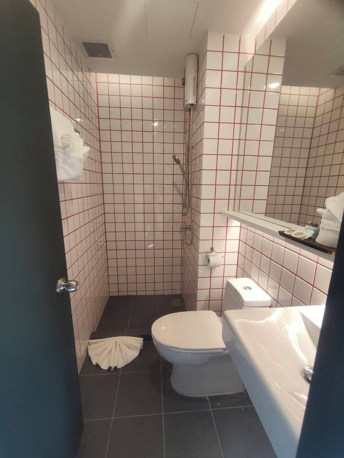 A bathroom with a shower, toilet, and sink.