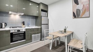 Una cocina moderna con horno Bosch, refrigerador y comedor con mesa y sillas.