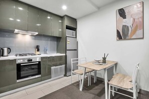 Cuina moderna amb forn Bosch, frigorífic i zona menjador amb taula i cadires.