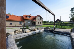 A house with a swimming pool, a stone pathway, and a clear sky.