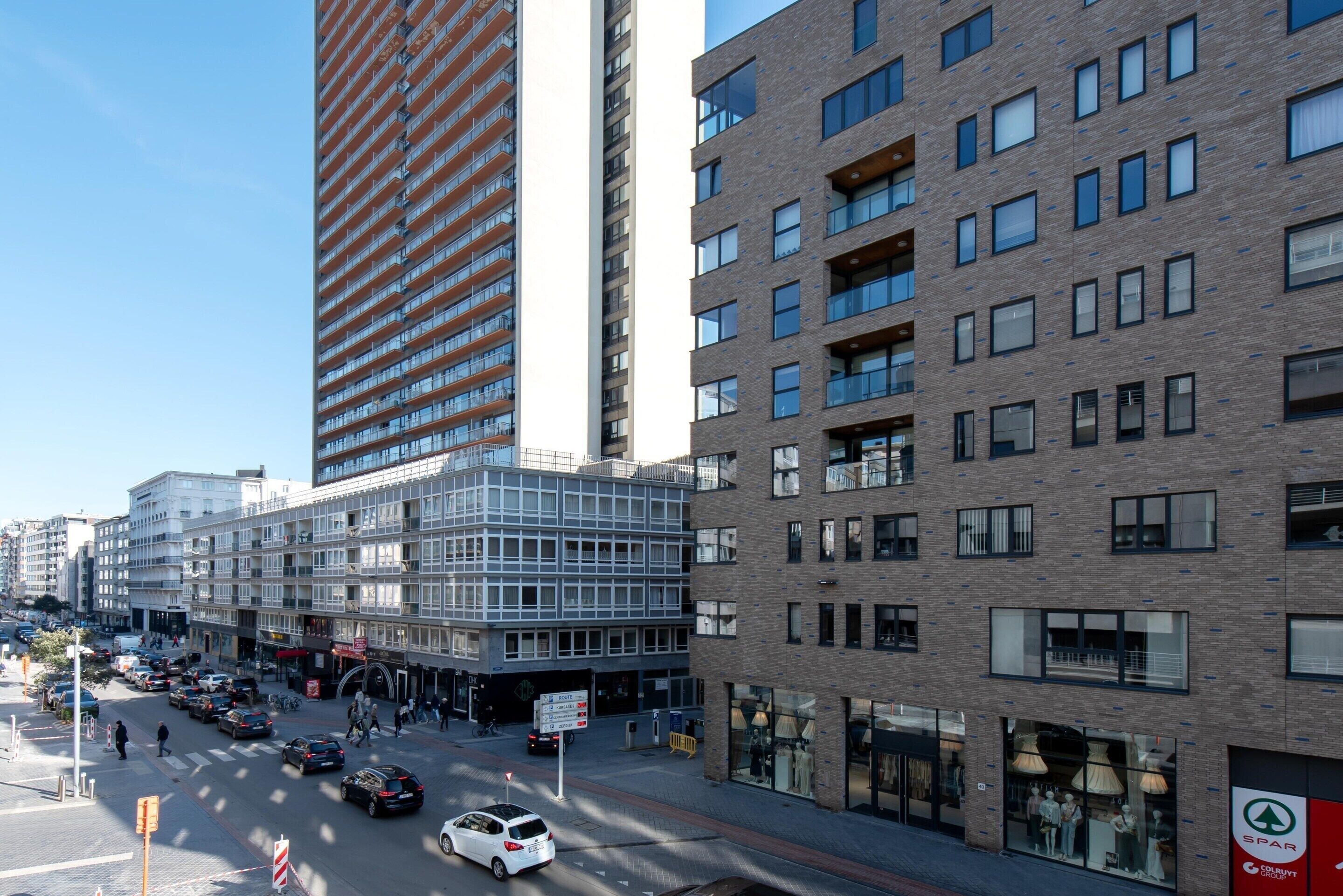A multi-story building with a modern architectural design, featuring a mix of glass and brick facades.