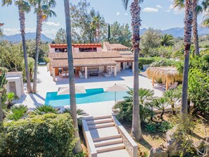 Una villa con piscina, area relax esterna e vista sulle montagne.