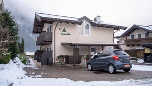 Rakennuksen edessä on kyltti, jossa lukee ”Das Taubenhaus”, ja sen eteen on pysäköity auto.