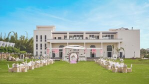 A building with a formal outdoor setting, including a decorated archway and rows of chairs. - Treat Imperial Jim Corbett (Ramnagar)
