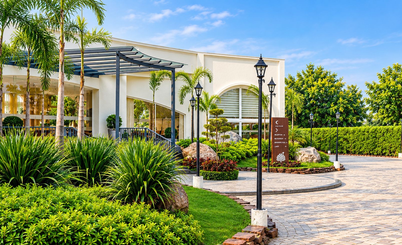 A hotel entrance with a covered walkway, palm trees, and a landscaped garden.