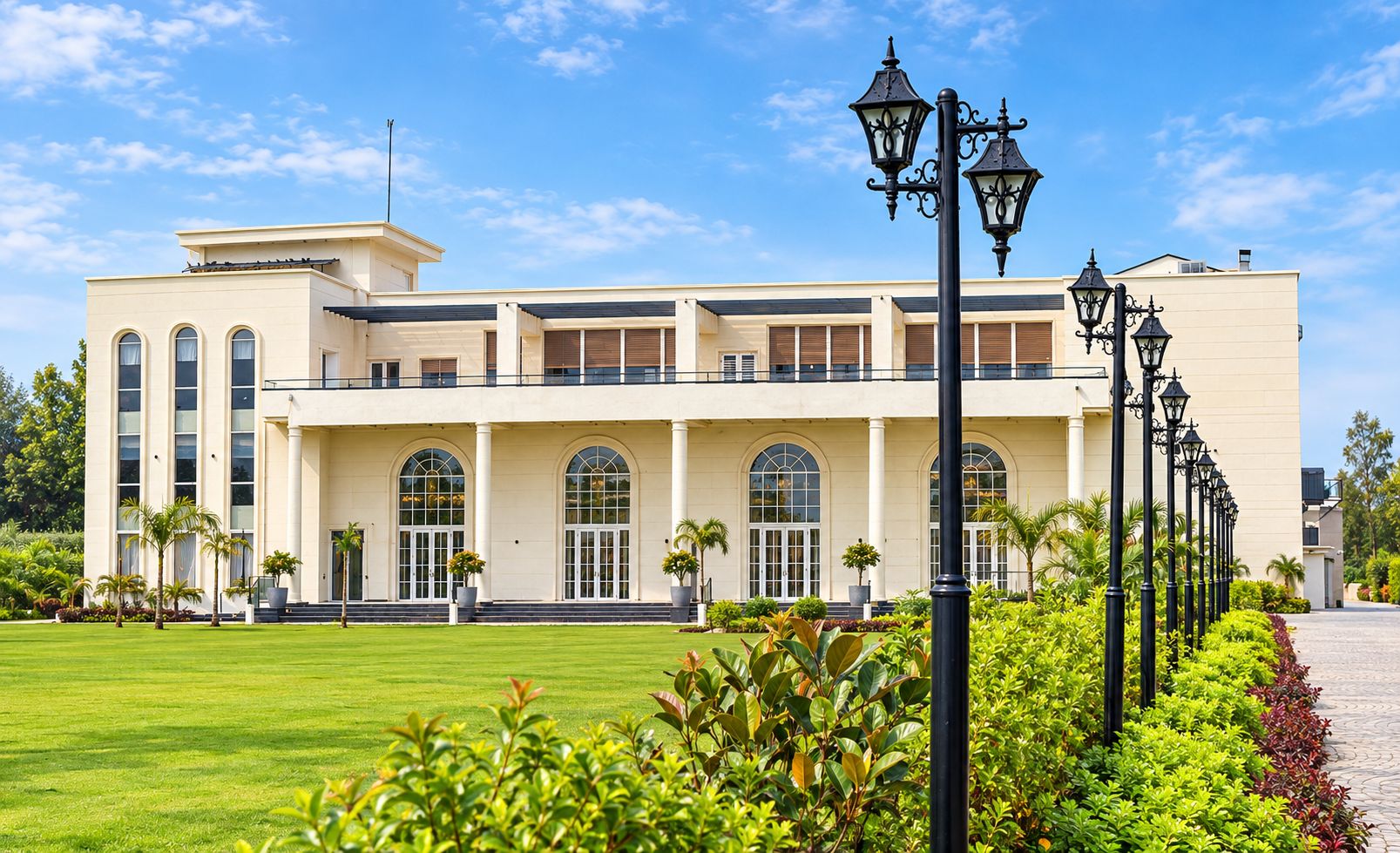 A large, modern building with a symmetrical facade, large windows, and a well-maintained lawn.