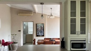 A kitchen with a large island, a microwave, and a dining area with a table and chairs. - Heritage Charmer | Roomy and cosy | Central Orange (Orange)