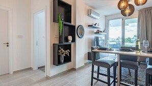 A modern kitchen with a dining area, built-in shelves, and a large window with a view. - Sunshine 1-BR Apt. & Blacony in Larnaca (Larnaca)