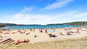 A beach with people sunbathing, umbrellas, and a clear sky. - BALO4 - Balmoral Beauty | Elevated Living On The Esplanade (Mosman)