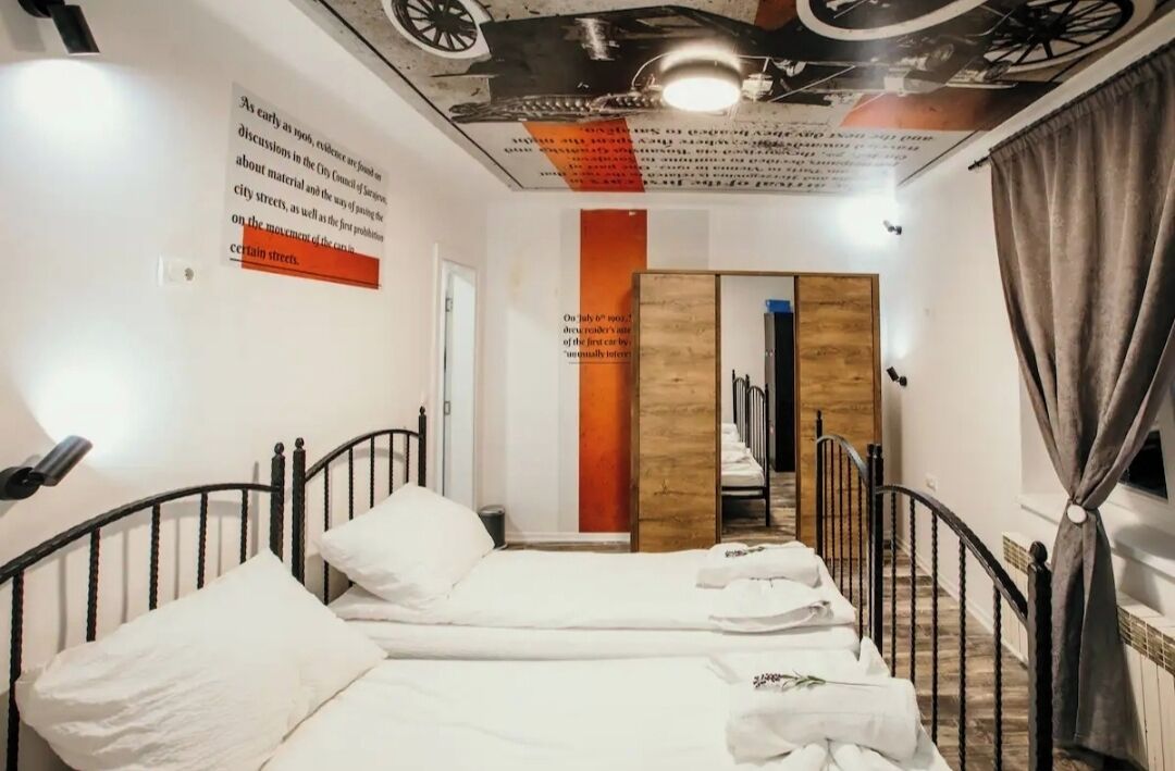 Ein Hotelzimmer mit Bett, Spiegel, einer Wandpaneele aus Holz und einer Treppe.