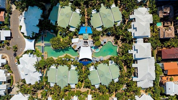 An aerial view of a resort with multiple buildings, a central pool area, and surrounding greenery. - Coastal Luxe - Diamond Beach 168 (Mermaid Beach)