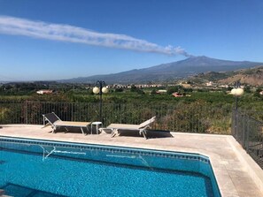 A swimming pool with lounge chairs and a view of a mountain. - Villino Lenci (Trappitello)