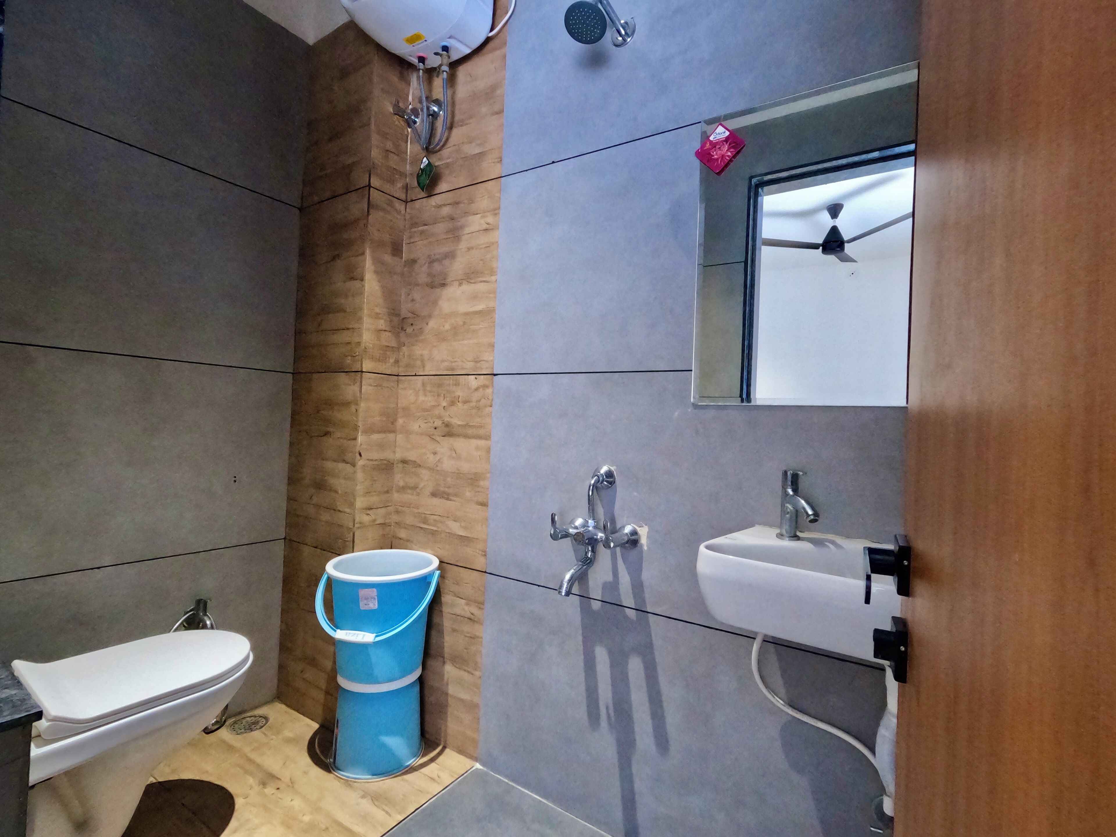A bathroom with a toilet, sink, and shower.