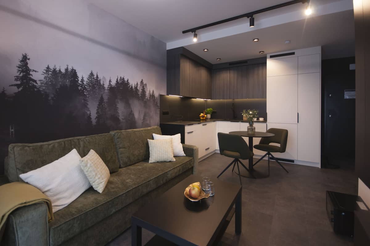 Un salon moderne comprenant un canapé, une table basse et un coin repas avec des chaises.