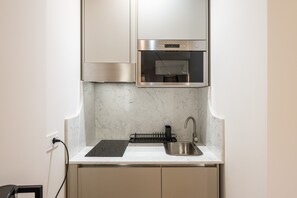 Eine kleine Küche mit Backofen, Spüle und Arbeitsplatte.