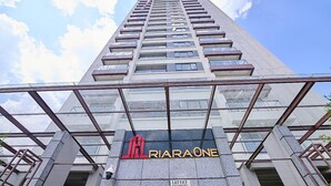 A tall building with a glass facade and the sign 'JAL RIARAONE' prominently displayed.