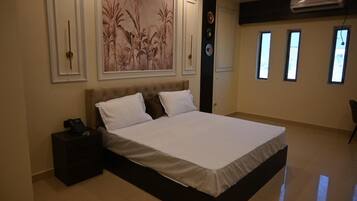 Un dormitorio con una cama grande, una mesita de noche, aire acondicionado de pared y una ventana.