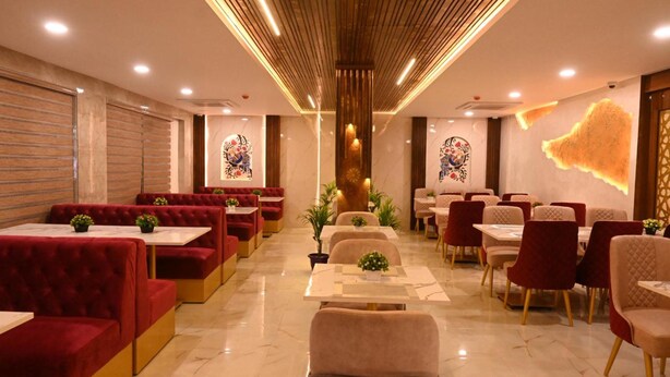 Un restaurante con cabinas y mesas, techo de madera y detalles decorativos en las paredes.