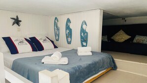 Un lit avec une couvre-lit bleue, des oreillers blancs ornés de motifs et une décoration en forme d’étoile sur le mur.