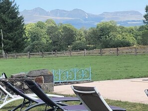 A grassy outdoor area with a stone wall, metal fence, and lounge chairs. - Quiet vacation home with swimming pool (Bagnols)