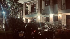 A two-story building with a car parked in front.