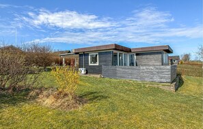 A modern single-story house with a sloped roof, large windows, and a visible garage door. - 2 bedroom stunning home in Roslev (Roslev)