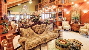 A spacious room with a large ornate sofa, multiple chairs, and a decorative mirror. - Luxe Waterfront Living: Portland Home w/ Pier! (Portland)
