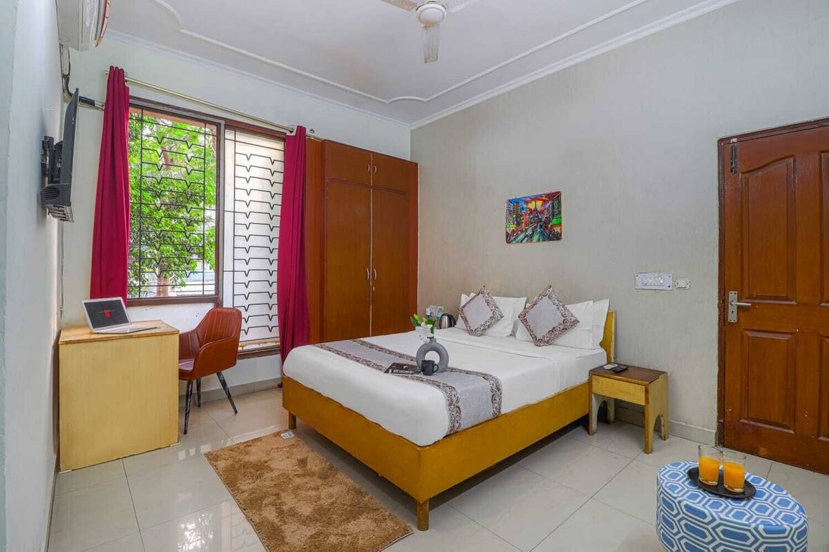 Une chambre à coucher comprenant un lit, un bureau, une chaise et une armoire.