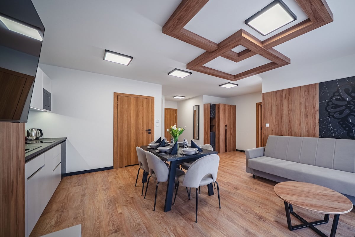 A modern living space with a dining area, a sofa, and a coffee table.