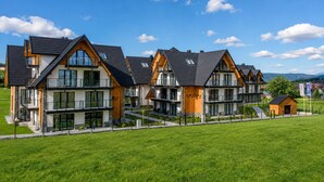 Ein moderner Wohnkomplex mit mehreren zweistöckigen Häusern, jedes mit einem Balkon und einer flachen Dachfläche.