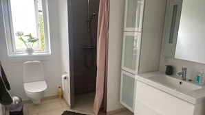 Un baño moderno con inodoro, ducha y lavabo.
