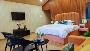 Una camera da letto moderna con un letto grande, una TV a schermo piatto, un tavolino con un vaso e una sedia.