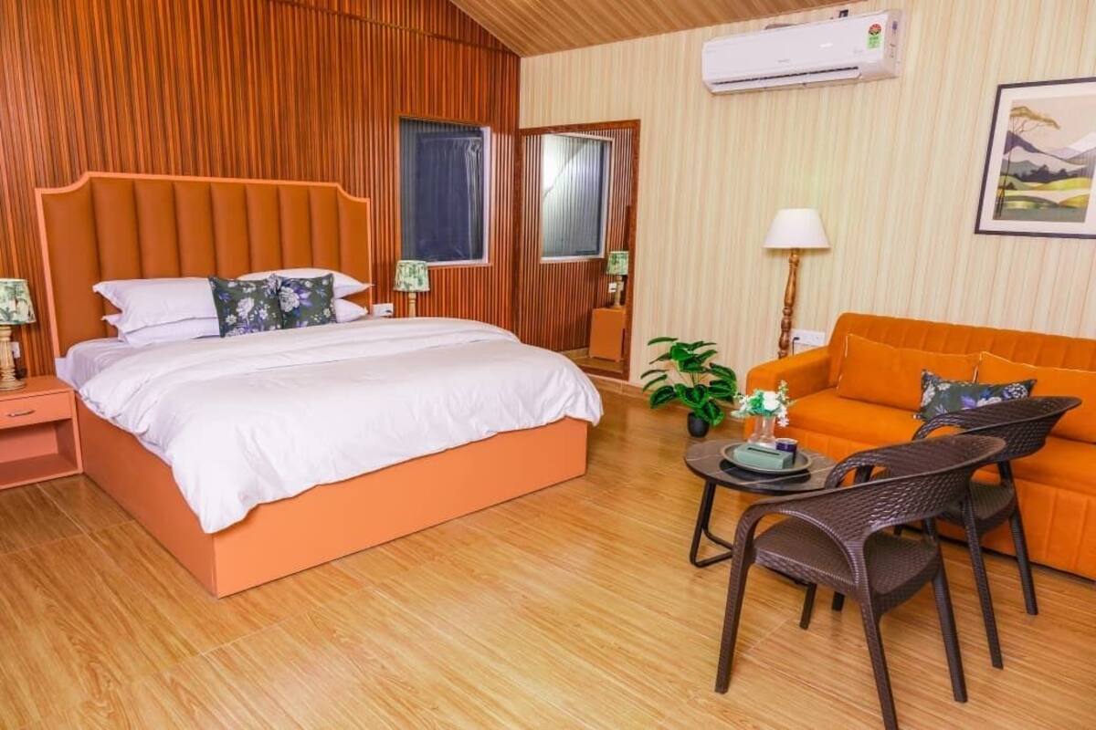 Une chambre à coucher avec un lit, un canapé, une table et une chaise.