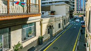 Vista de la calle con un edificio que tiene balcones y un rascacielos moderno al fondo.