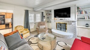 Ein Wohnzimmer mit Kamin, Fernseher, Sofa und Couchtisch.