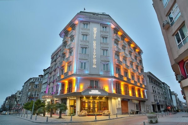 A hotel with a prominent sign, multiple floors, and a corner location.