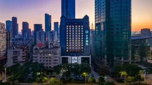 A cityscape with modern high-rise buildings, including a hotel with a prominent sign. - Ji Hotel Wuhan Hankou Xinhua Road (Wuhan)