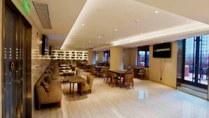 A spacious hotel lobby with a seating area, a reception desk, and a large window offering a city view. - Ji Hotel Wuhan Hankou Xinhua Road (Wuhan)
