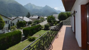 Un balcone con vista su una zona residenziale e montagne.
