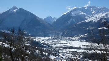 A mountainous landscape with snow-covered peaks and a valley below.