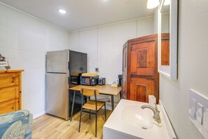 Une cuisine compacte équipée d’un réfrigérateur, d’un four à micro-ondes, d’un grille-pain et d’une armoire en bois.