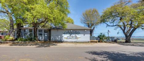 A building with a mural, trees, and a clear sky.