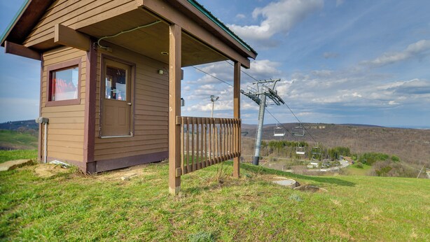 A small wooden cabin with a porch, a window, and a door. - Ski-In/Ski-Out Seven Springs Mtn Condo w/ Shuttle! (Champion)