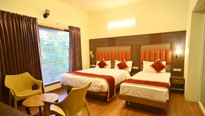 A hotel room with two beds, a small table, two chairs, a window with curtains, and a nightstand with a lamp. - KULIR KODAI INN  (Kodaikanal)