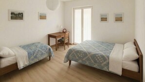 Ein Schlafzimmer mit zwei Betten, einem Schreibtisch und einem Stuhl.