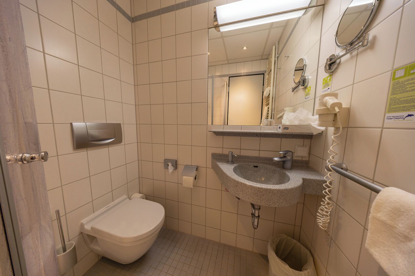 Un bagno piccolo ma funzionale, con il water, lavandino e specchio.