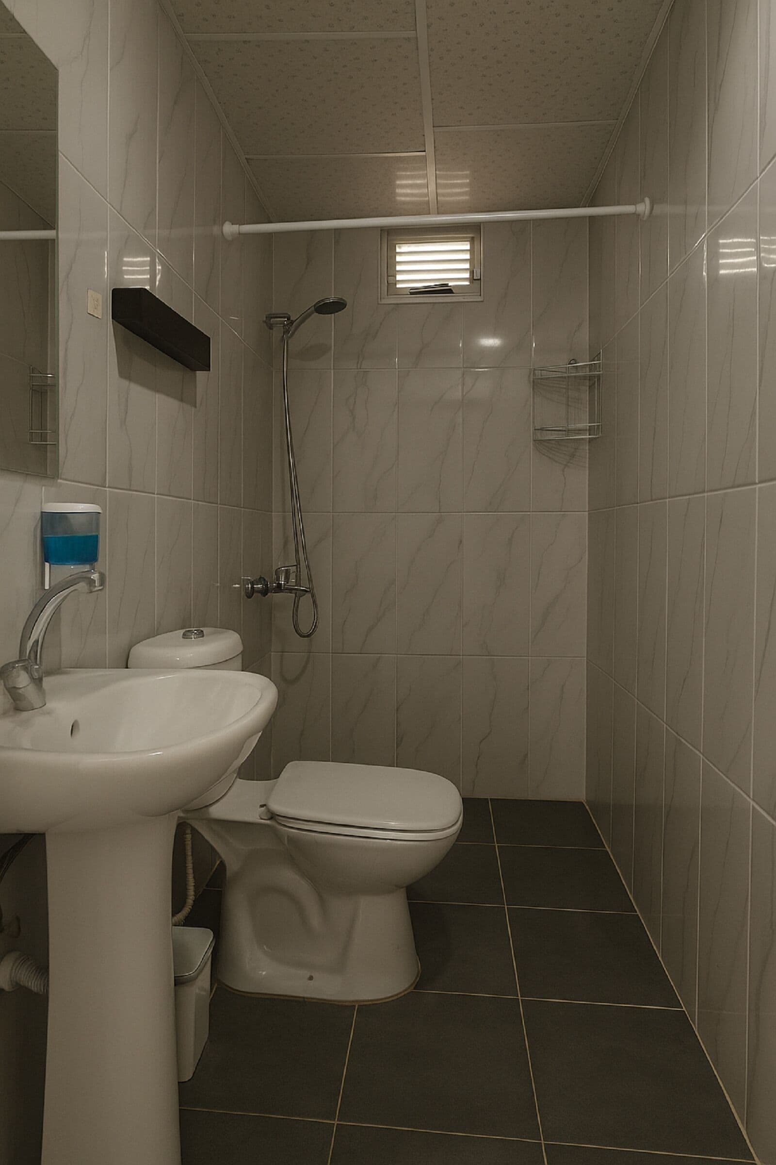 Un baño con lavamanos, inodoro y ducha.