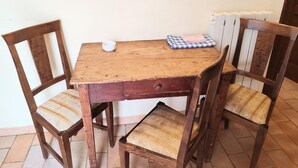 A wooden table with two chairs, a small white bowl, and a checkered cloth on the table. - Apartment in Umbria Near Montefalco Winery (Giano dell'Umbria)